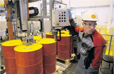  ?? ANDREY RUDAKOV / BLOOMBERG FILES ?? An employee at a control panel as barrels are filled with oil ahead of shipping at Royal Dutch Shell PLC’s lubricants-blending plant in Torzhok, Russia.