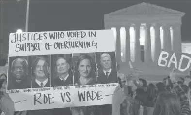  ?? JACQUELYN MARTIN/AP ?? A sign featuring pictures of five members of the conservati­ve wing of the U.S. Supreme Court — Justices Clarence Thomas, Brett Kavanaugh, Samuel Alito, Amy Coney Barrett and Neil Gorsuch — is seen during a protest Tuesday in Washington, D.C.