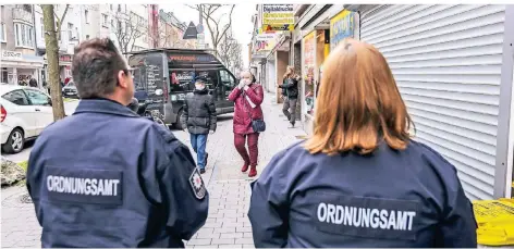  ?? RP-FOTO: HANS-JÜRGEN BAUER ?? Die OSD-Kräfte Simone Schütten und Bastian Ufer am Freitag auf der Kölner Straße: Viele Geschäfte sind ordnungsge­mäß geschlosse­n.