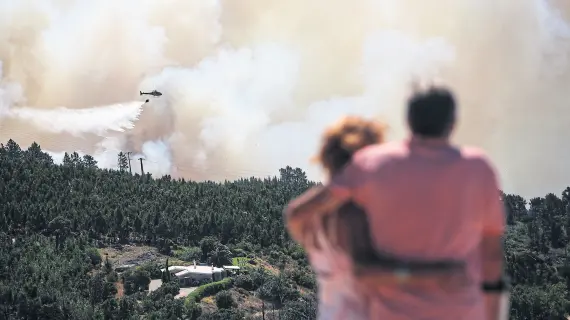  ?? Carlos costa/afp ?? Una pareja observa los intentos de frenar los incendios que asolan las cercanías de Monchique, en Portugal