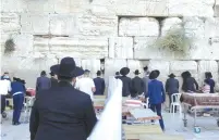  ??  ?? WORSHIPERS DIVIDED into ‘ capsules’ pray at the Western Wall yesterday. ( Marc Israel Sellem/ The Jerusalem Post)