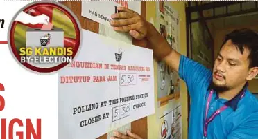  ?? PIC BY SYARAFIQ ABD SAMAD ?? An Election Commission officer setting up a voting centre in Sungai Kandis yesterday.