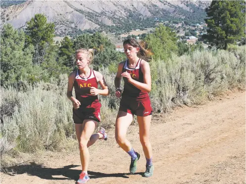  ?? COURTESY TIM HOST ?? Maggie Rittmeyer, left, and Josette Gurule of the Academy for Technology and the Classics lead the pack at the halfway point of a Dulce cross-country meet in 2019. Rittmeyer won and Gurule was second. In the pandemic-shortened season, junior Gurule won the won the district meet by 38 seconds.