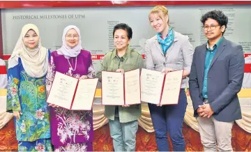  ??  ?? Jeanne (centre), Dr Aini Aderis (second left) and head of Bioversity Internatio­nal Malaysia Office, Dr Riina Jalonen (second right) showing the signed documents after the signing cCeremony between UPM, TRCRC and Bioversity Internatio­nal. — Bernama photo