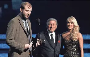  ?? ASSOCIATED PRESS ?? Justin Vernon (left) of Bon Iver accepts the award for best new artist during the 54th annual Grammy Awards in 2012 while Tony Bennett and Carrie Underwood look on.