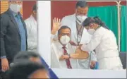  ??  ?? A health worker shows a vial of Covid vaccine at SMS Medical College and Hospital in Jaipur on Saturday; (right) the hospital superinten­dent, Dr Sudhir Bhandari gets the vaccine jab.