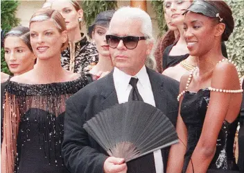  ?? PIERRE VERDY/AFP/GETTY IMAGES ?? Canadian model Linda Evangelist­a, left, designer Karl Lagerfeld and British model Naomi Campbell at Chanel’s fall/winter 1996-1997 collection in Paris.