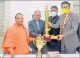  ?? HT PHOTOS ?? (Above) Chief minister Yogi Adityanath and additional chief secretary (informatio­n) Navneet Sehgal with the trophy and below the certificat­e.
