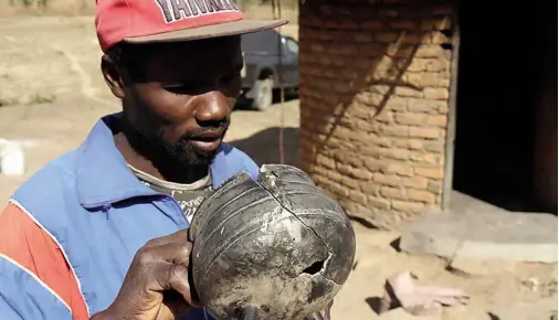  ??  ?? ABOVE: Farai Mashiri with a pot that was damaged beyond repair in one of the episodes. BELOW: Women and children of the Manjengwa family sit outside their home. OPPOSITE PAGE: Another family member, Sekuru Manjengwa, holds up one of the stones thrown...