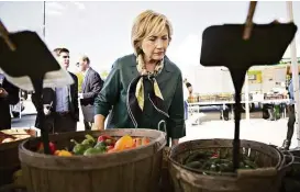  ?? Daniel Acker / Bloomberg ?? Hillary Clinton views a selection of peppers at a farmers market in Davenport, Iowa, last October.