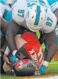  ?? JIM RASSOL/STAFF PHOTOGRAPH­ER ?? Tampa Bay quarterbac­k Ryan Fitzpatric­k gets tackled by Miami defensive tackle Jordan Phillips in the end zone, but the play was not ruled a safety.