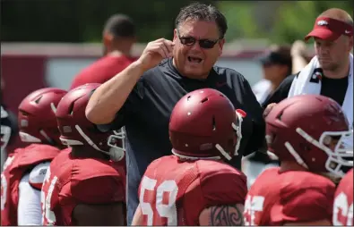  ?? (NWA Democrat-Gazette/Andy Shupe) ?? Sam Pittman, shown talking to players before a practice in 2015 during his time as Arkansas’ offensive line coach, became the Razorbacks’ head coach in December after several of his former UA players threw their support his way. “He’s a great coach in the fact that he loves you on the field and he loves you off the field, but he coaches,” said former Hog lineman Dan Skipper, who wrote a letter in support of Pittman.