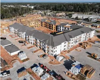  ?? Jason Fochtman / Staff photograph­er ?? Constructi­on on an apartment complex continues Dec. 23 along Grand Village Boulevard in the master-planned community of Grand Central Park in Conroe.