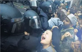  ??  ?? SUPPORTERS of the vote confront police, who smashed windows, cut internet cables, swung billy clubs and fired rubber bullets, injuring hundreds in Catalonia.