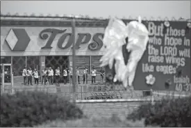  ?? JOSHUA BESSEX, FILE/AP PHOTO ?? Investigat­ors stand outside during a moment of silence Saturday for the victims of the Buffalo supermarke­t shooting at the Tops Friendly Market.