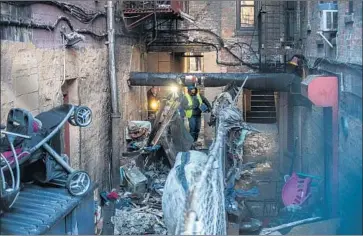  ?? Andres Kudacki Associated Press ?? POLICE INSPECT a fire-ravaged apartment building in the Bronx. Flames blocked some people from escaping down the stairwell of the walk-up building, while others were overcome by smoke, authoritie­s said.