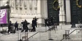  ?? TED SHAFFREY — THE ASSOCIATED PRESS ?? New York police officers move in on the scene of a shooting at the Cathedral Church of St. John the Divine, Sunday, Dec. 13, in New York.