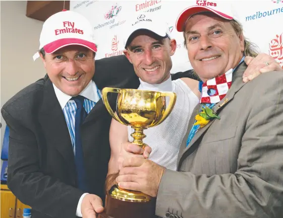  ??  ?? Lee Freedman (left), jockey Glen Boss and owner Tony Santic celebrate Makybe Diva’s historic third Melbourne Cup win 2005. Picture: Getty Images