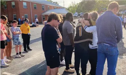  ?? ?? People embrace at a prayer vigil on 16 April 2023 outside First Baptist church in Dadeville, Alabama, a day after a mass shooting at a teenager's birthday party. Photograph: Jeff Amy/AP