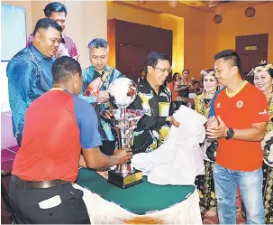  ??  ?? RASMI: Dr Rundi (dua kanan) membuka kain penutup piala pusingan simbolik perasmian penutupan Kejohanan Bola Sepak Luar Bandar Bahagian Bintulu malam kelmarin.