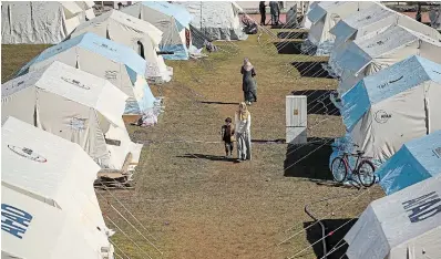  ?? EMRAH GUREL THE ASSOCIATED PRESS ?? People walk in a tented camp set up for survivors in Adiyaman, southern Turkey, on Monday.