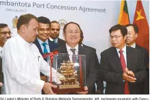  ?? AFP-Yonhap ?? Sri Lanka’s Minister of Ports & Shipping Mahinda Samarasing­he, left, exchanges souvenirs with Executive Vice President of China Merchants Port Holdings Dr. Hu Jianhua during the Hambantota Internatio­nal Port concession agreement at a signing ceremony...