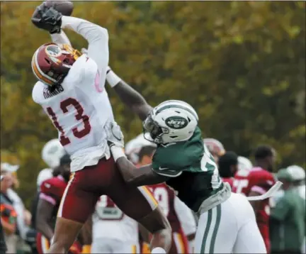  ?? STEVE HELBER — THE ASSOCIATED PRESS ?? Washington Redskins wide receiver Maurice Harris (13) grabs a pass over New York Jets defensive back Terrence Brooks (23) during the New York Jets Washington Redskins NFL football training camp in Richmond, Va., Monday.