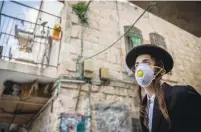  ?? (Yonatan Sindel/Flash90) ?? AN ULTRA-ORTHODOX youth wears a face mask in the orthodox Jewish neighborho­od of Mea She’arim, Jerusalem, yesterday.