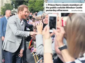  ?? Jonathan Brady ?? &gt; Prince Harry meets members of the public outside Windsor Castle yesterday afternoon