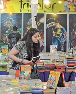  ?? — BIPLAB BANERJEE ?? A visitor browses through books at the Delhi Book Fair, which began at Pragati Maidan in New Delhi on Saturday. The fair was inaugurate­d by Union minister of science and technology Harsh Vardhan. A guide and a mobile app for the fair was also launched.