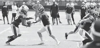  ?? KEVIN RICHARDSON/BALTIMORE SUN ?? Ravens quarterbac­k Trace McSorley, center, hands the ball to running back Kenneth Dixon, left.