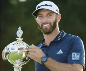  ??  ?? Dustin Johnson, of the United States, hoists the Canadian Open championsh­ip trophy at the Glen Abbey Golf Club in Oakville, Ontario, on Sunday. NATHAN DENETTE/THE CANADIAN PRESS VIA AP