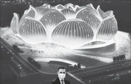  ?? XINHUA ?? Guangzhou Evergrande head coach Fabio Cannavaro poses in front of an image of the club’s planned new 100,000-seat stadium.