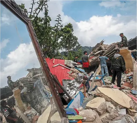  ?? — reuters ?? Searching for signs of life: rescuers looking for victims in the rubble of collapsed buildings during a rescue operation after the quake hit Cianjur, West Java.