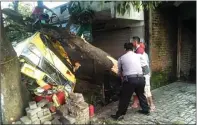  ?? EDI SUDRAJAT/ JAWA POS ?? LEPAS KENDALI: Warga dan polisi bahu-membahu mengangkat pohon yang menimpa truk engkel di Desa Pangkemiri, Tulangan, kemarin.