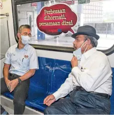  ??  ?? Keeping the distance: Tengku Zafrul (left) having a chat with Prasarana chairman datuk Seri Tajuddin abdul Rahman during a ride on the LRT.