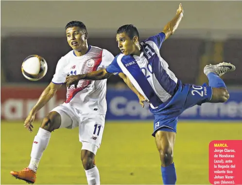  ??  ?? MARCA. Jorge Claros, de Honduras (azul), ante la llegada del volante tico Johan Vanegas (blanco).