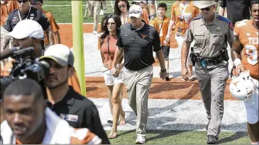 ?? RALPH BARRERA / AMERICAN-STATESMAN ?? Texas coach Tom Herman walks off the field hand-in-hand with his wife Michele after the 51-41 loss to Maryland on Saturday at home. San Jose State is next for Texas, also at home.