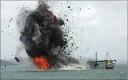  ?? M. URIP — THE ASSOCIATED PRESS FILE ?? Debris flies into the air as foreign fishing boats are blown up by the Indonesian Navy off Batam Island, Indonesia, as authoritie­s sank dozens of fishing boats caught operating illegally in Indonesian waters.