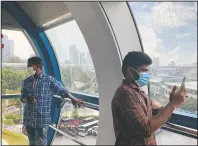  ??  ?? Migrant worker Natarajan Pandiaraja­n (right) enjoys the view on board the Singapore Flyer.