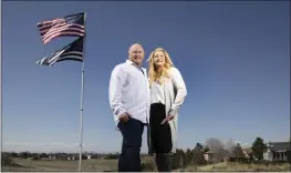  ?? KYLE GREEN — THE ASSOCIATED PRESS ?? Jennifer and Tim Kohl pose for a photo in their front yard with the American flag and a thin blue line flag in Star, Idaho, on April 14. The couple recently moved to Idaho from the Los Angeles area.