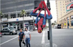  ?? AP PHOTO ?? Rashad Rouse, 27, whose dream is getting his star on the Hollywood Walk of Fame, hangs upside down from a traffic signal pole in a Spider-Man costume to get attention from tourists on Hollywood Boulevard, in Los Angeles.