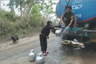  ?? ASSOCIATED PRESS ?? Tonchuiwon Tinphei (left) fills water after a tanker cleaning a road allowed her to fill a few vessels in the northeaste­rn Indian state of Manipur on Saturday.