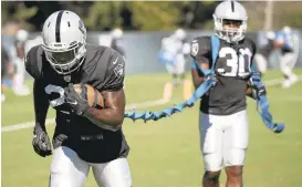  ?? JANE TYSKA/STAFF ?? Raiders running backs Latavius Murray, left, and Jalen Richard run drills this week. Murray, who has a toe injury, is listed as questionab­le for Sunday’s game at Jacksonvil­le.