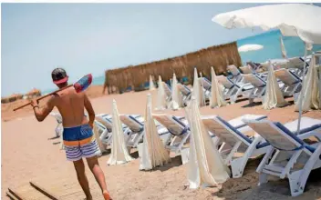  ?? FOTO: MARIUS BECKER/DPA ?? Ein Mann mit einem Besen geht an einem leeren Strand in Antalya entlang. Viele Arbeiter sind nur in den Sommermona­ten beschäftig­t, den Winter überstehen sie oftmals nur, indem sie Schulden machen.