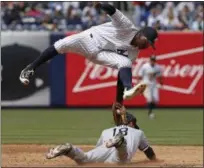  ??  ?? New York Yankees shortstop Didi Gregorius (18) catches Chicago White Sox Tyler Saladino stealing second for an out during the sixth inning of a baseball game in New York, Sunday. The Yankees defeated the White Sox 7-5.