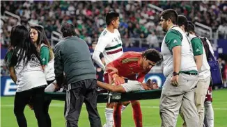  ?? Associated Press ?? El portero Guillermo Ochoa se acerca a alentar a Néstor Araujo mientras su compañero de equipo y zaguero es retirado del campo de juego tras sufrir una lesión durante la derrota de México frente a Croacia en Arlington, Texas.