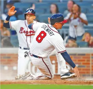  ?? THE ASSOCIATED PRESS ?? The Atlanta Braves’ Chris Stewart (8) slides into home for the second run scored off Ender Inciarte’s double in the second inning of Saturday’s 15-2 win over the Philadelph­ia Phillies in Atlanta.