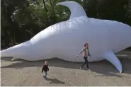  ?? AP FILE PHOTO/MARCO UGARTE ?? A woman and child walk past an inflatable representa­tion of a vaquita marina porpoise in 2018 during a procession for the critically endangered animal in Mexico City.