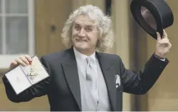  ??  ?? 0 Playing up for the press, the Big Yin shows off his CBE, which he received from the Prince of Wales at Buckingham Palace in December 2003 in recognitio­n of his services to entertainm­ent